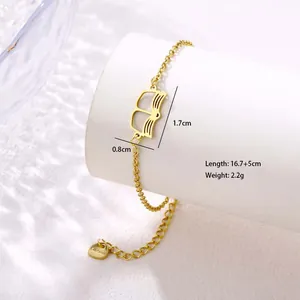 Detail of gold hollow book pendant bracelet with extension chain and heart tag