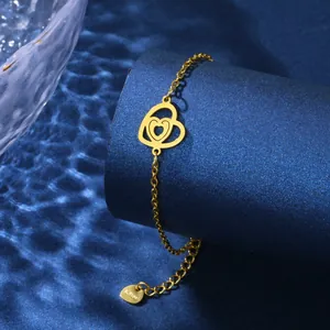Polished gold stainless steel chain bracelet featuring hollow double heart charms on blue display