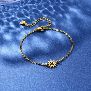 Gold stainless steel sun charm bracelet with spiral pattern on blue water texture background