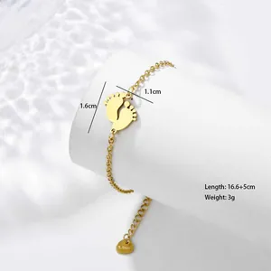 Detail of baby feet pendants on a gold stainless steel bracelet with measurement marks