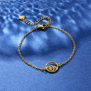 Minimalist gold stainless steel eye bracelet with hollow round pendant on blue water texture