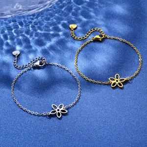 Gold and silver stainless steel chain bracelets with hollow floral pendants on blue water
