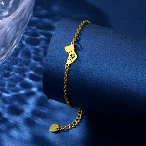 Golden stainless steel Christmas sock bracelet with hollow floral charm on display