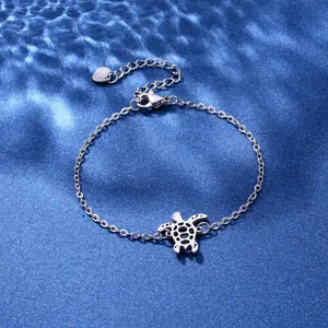 Polished stainless steel turtle pendant bracelet with adjustable chain on blue background