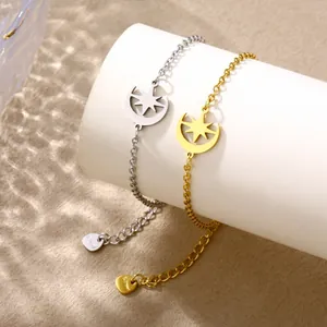 Gold and silver stainless steel star and moon charm bracelets on display with water ripple shadow