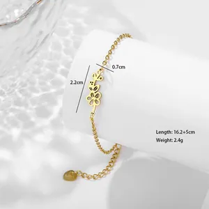Détail d'un bracelet fleuri en acier doré avec chaîne réglable et pendentif en cœur