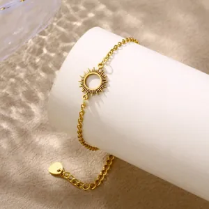 Bracciale in acciaio inossidabile dorato con ciondolo a sole su supporto bianco tondo