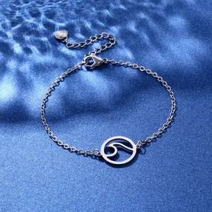 Macro shot of silver wave pendant bracelet with S925 engraved heart tag on blue water background