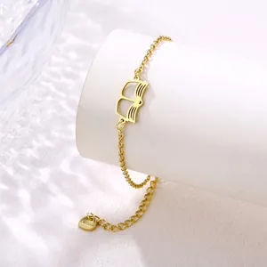 Detail of gold stainless steel book pendant bracelet with heart charm on a white stand