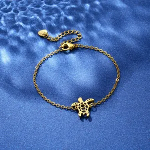 Detailed close-up of golden stainless steel bracelet featuring a delicate hollow turtle charm