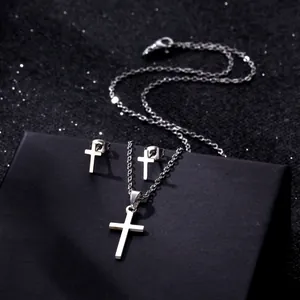 Polished stainless steel cross necklace and stud earrings set on a black display box