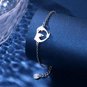 Close-up of stainless steel bracelet featuring a minimalist heart dolphin charm