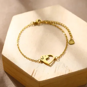 Golden heart-shaped dog paw bracelet with adjustable extension chain on wooden base