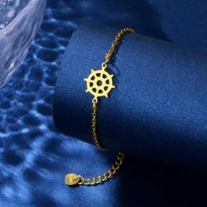 Detailed view of golden ship wheel pendant and adjustable chain on a blue pedestal
