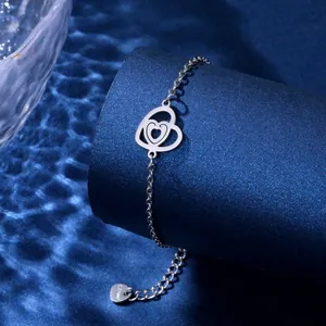 Detail of hollow double heart pendant on stainless steel chain over water ripple background