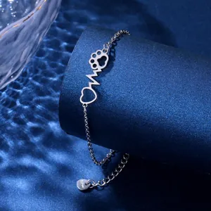 Detailed macro view of silver stainless steel bracelet with heart and paw print charms