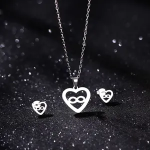 Polished silver heart jewelry set with infinity symbol on a sparkling black background
