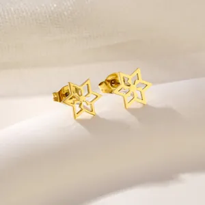 Polished gold stainless steel star stud earrings on white podium display
