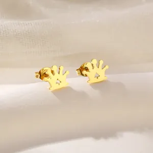 Macro view of golden crown stud earrings with butterfly backings on soft fabric