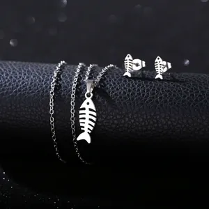 Detailed view of silver stainless steel fishbone necklace and earrings on black leather