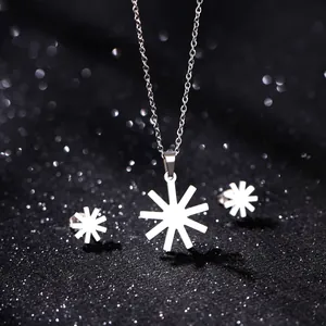 Macro view of silver starburst pendant necklace and stud earrings set on black background