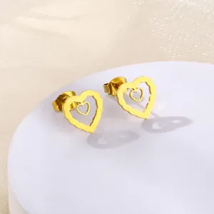 Close-up of golden hollow double heart stud earrings in minimalist stainless steel