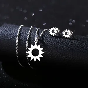 Close-up of silver stainless steel sunburst necklace and earring set on black leather