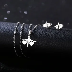 Detailed close-up of silver stainless steel heart and heartbeat necklace and earrings set