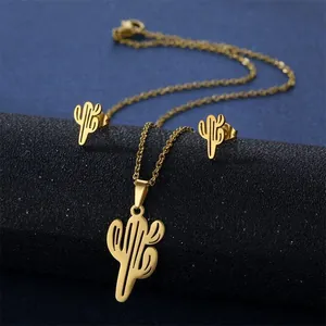 Detailed close-up of golden cactus pendant and earrings set on dark textured display