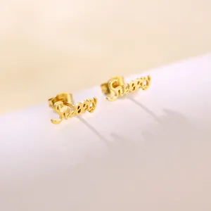 Macro shot of polished gold-plated Sweet script stud earrings with smooth finish