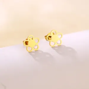 Detailed close-up of golden hollow five-petal flower stud earrings with a polished finish