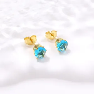 Vue détaillée des boucles d'oreilles couronne en acier doré et cristaux zircon bleu ciel