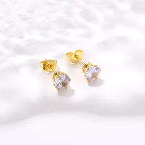 Détail de boucles d'oreilles couronne dorées avec des pierres d'oxyde de zirconium