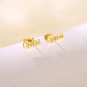 Macro shot of gold stainless steel Queen letter stud earrings with small crown detail