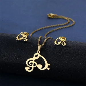 Golden treble clef heart jewelry set with necklace and earrings on a black stand