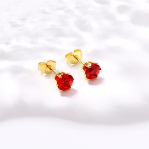 Détail macro de boucles d'oreilles en zircon rouge avec monture à six griffes