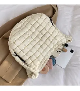 Spacious interior of white quilted cloud bag showing tablet, phone, and cosmetics