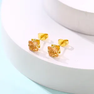 Vue détaillée de boucles d'oreilles carrées en zircon champagne et monture dorée