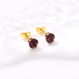 Vue détaillée de boucles d'oreilles couronne en acier doré avec zircons violets ronds