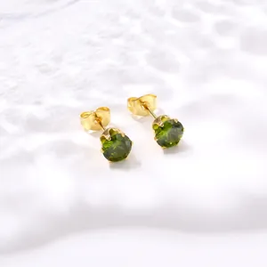 Vue détaillée de boucles d'oreilles couronne en zircon vert et acier plaqué or