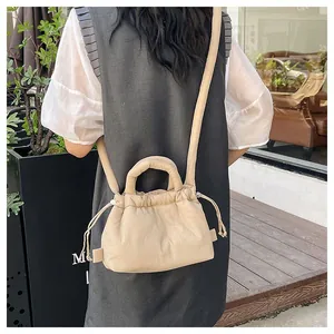 Macro detail of the beige puffer cloud bag with drawstring closure and puffy shoulder strap