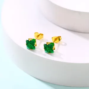 Vue macro des boucles d'oreilles carrées vert émeraude avec finition dorée et fermoirs papillon