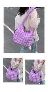 Detail of purple quilted hobo bag featuring thick shoulder strap and puffer texture