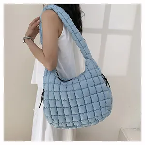 Close-up of light blue quilted cloud bag showing puff texture and side drawstring detail