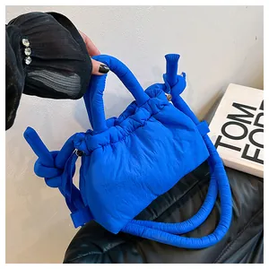Detail of electric blue quilted cloud bag featuring drawstring closure and knotted straps