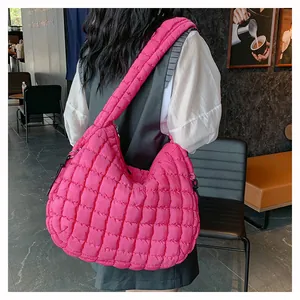 Detail of bright pink quilted puffer bag with chic bubble texture on wide shoulder strap