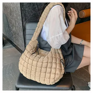 Close-up of khaki quilted puffer shoulder bag with square stitching and soft texture