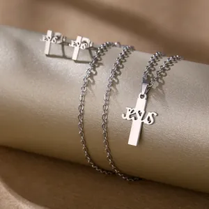 Macro view of silver stainless steel cross jewelry set with JESUS engraved details