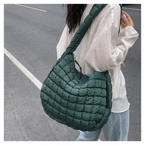 Macro view of dark green quilted bubble bag texture and soft padded shoulder strap