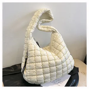 Close-up of beige quilted cloud bag with padded nylon texture and black zipper detail